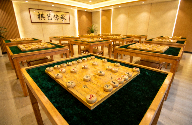 智慧棋院内明亮的对弈空间与整齐排列的棋盘桌